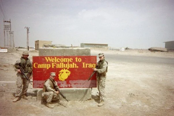 The author standing on the Camp Fallujah field with three colleagues during deployment in Iraq (bottom right).